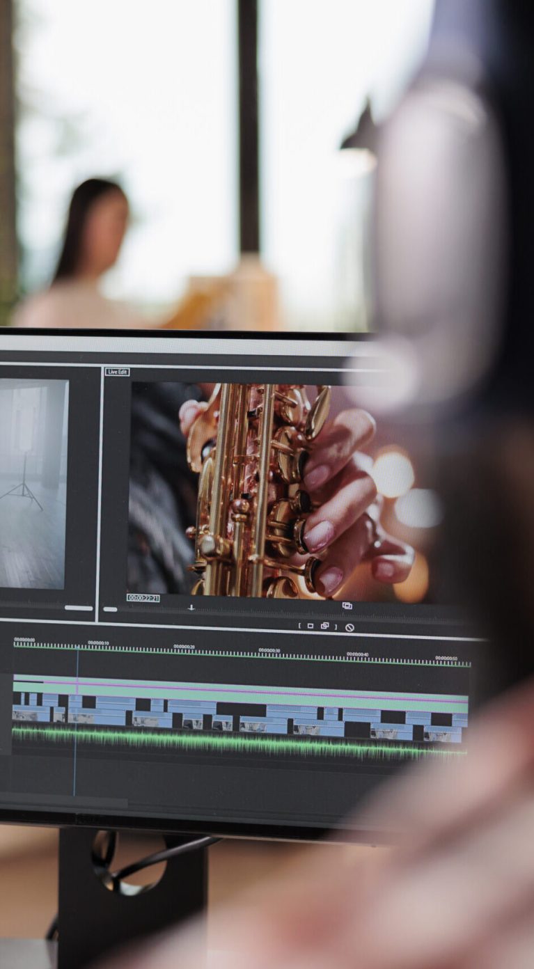 Young freelancer editing footage on software, working to edit video montage with color grading and audio effects. Sound and film production content, making creative movie on computer.